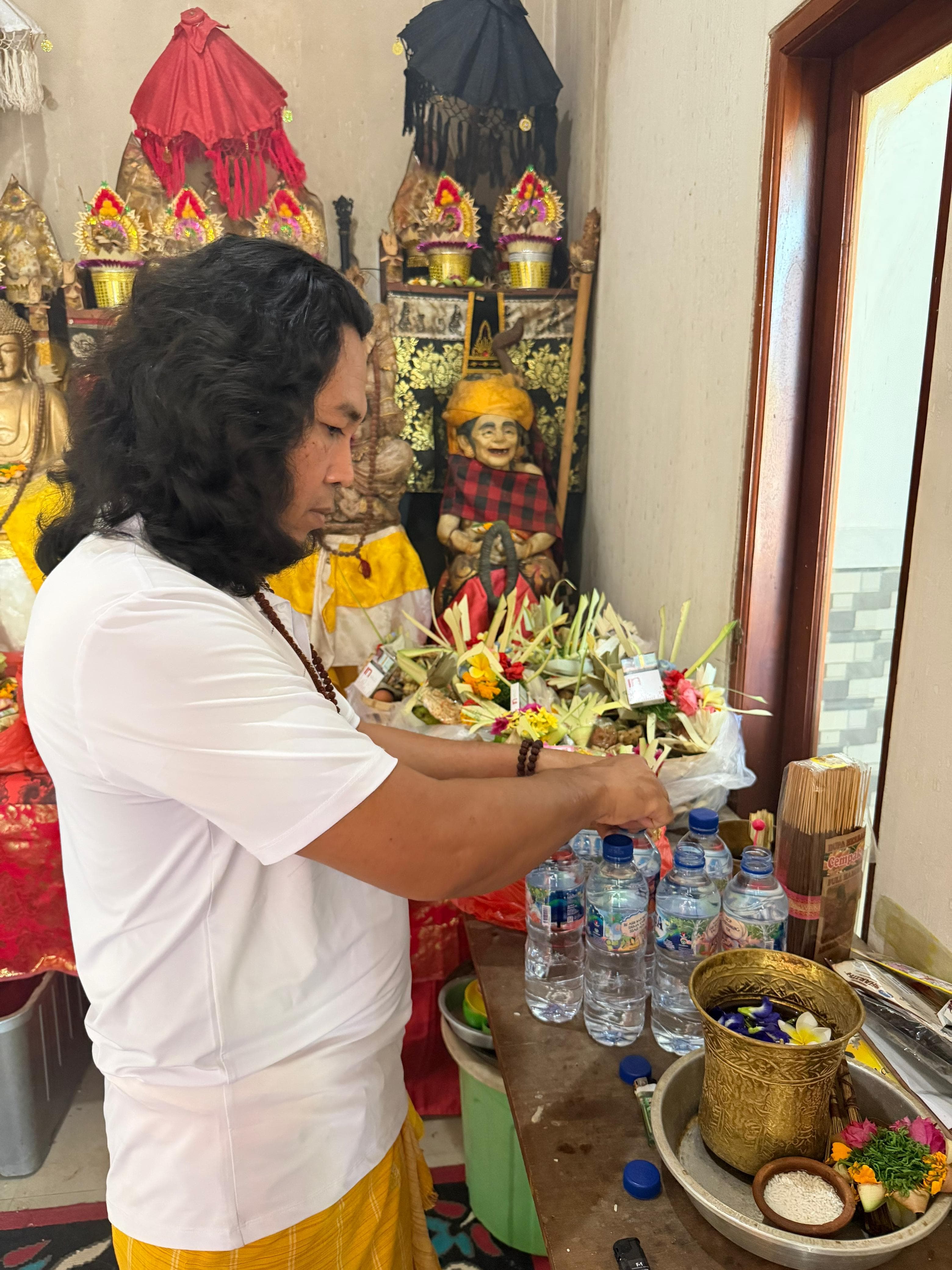 JRO offering holy water among offerings and sacred objects at his shrine.
